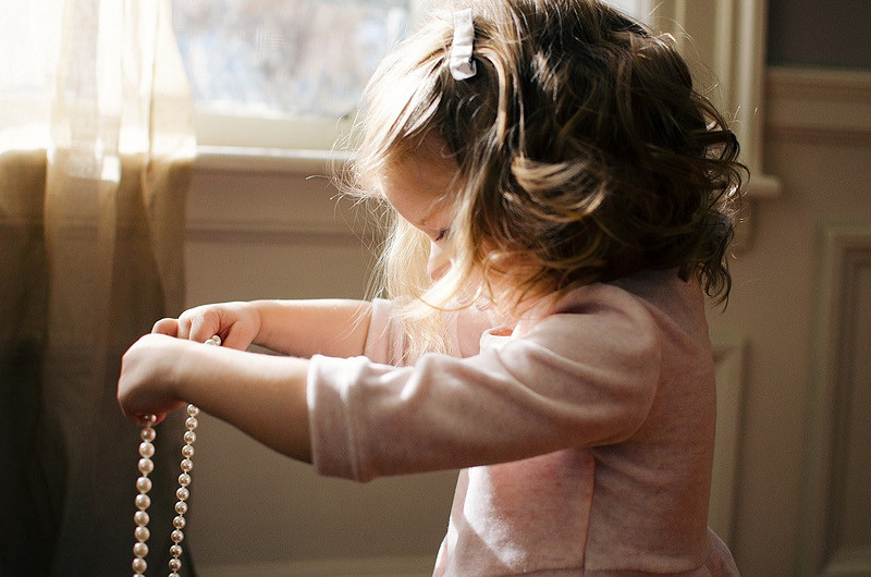A Young girl playing with pearls at a wedding | Laura Mares Photography | Pittsburgh Photographer